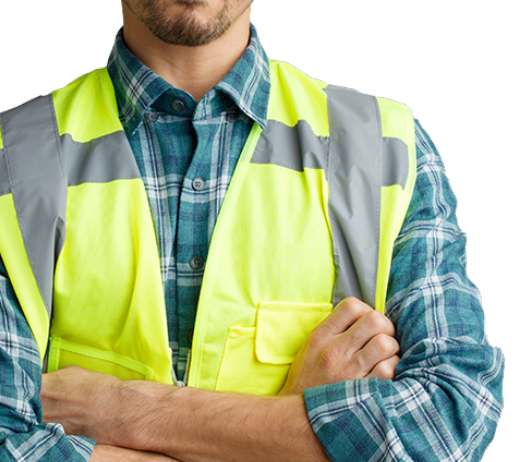A man wearing a yellow vest and plaid shirt, representing occupational health service, stands confidently in a professional setting.