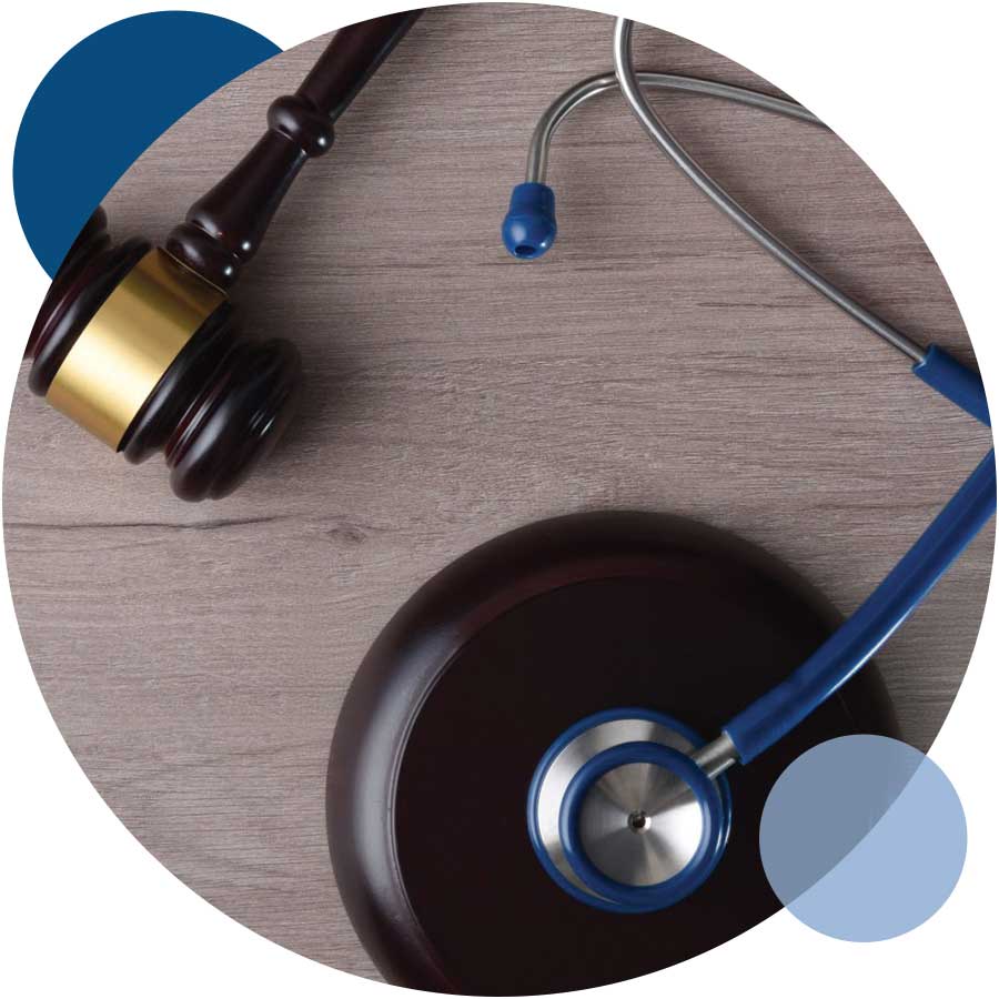 A medical stethoscope and gavel resting on a wooden table, symbolizing the intersection of medicine and law