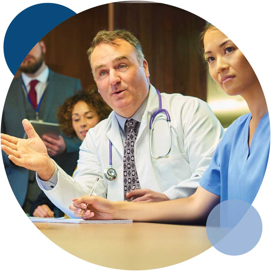 A medico-legal specialist doctor and a nurse seated at a table, engaged in a discussion