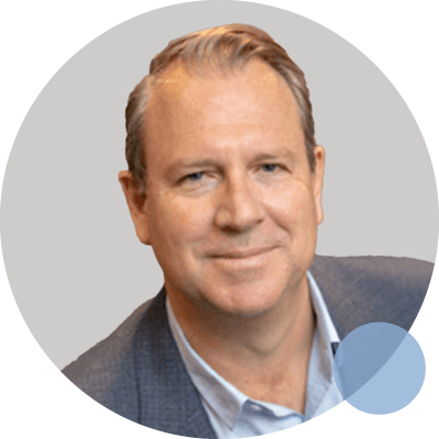 Professor Simon Collinson, a neuropsychologist, smiles confidently in a suit and tie, showcasing his professional demeanor.
